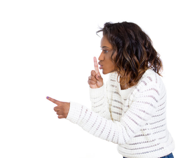 Woman with finger on lips gesture, asking to keep quiet